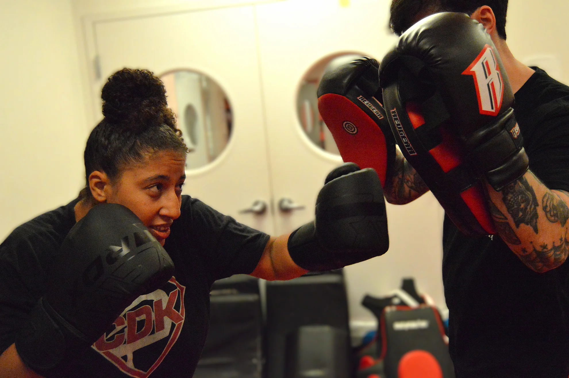 Woman practicing boxing combinations with a partner during a fitness and self-defense training session in Bethesda, Maryland.
