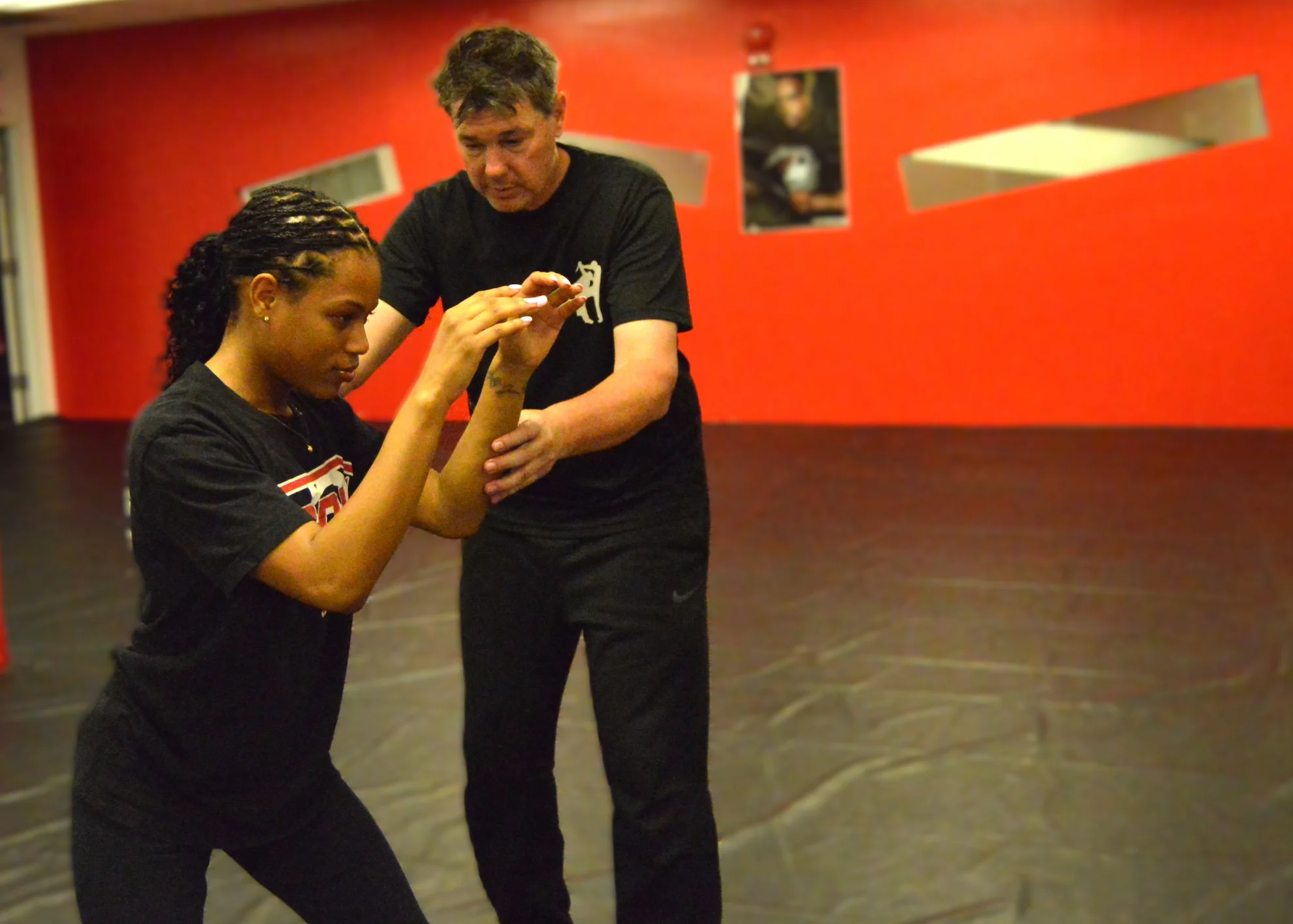 Instructor guiding a student through a defensive technique during private self-defense and Krav Maga training in Bethesda, Maryland.