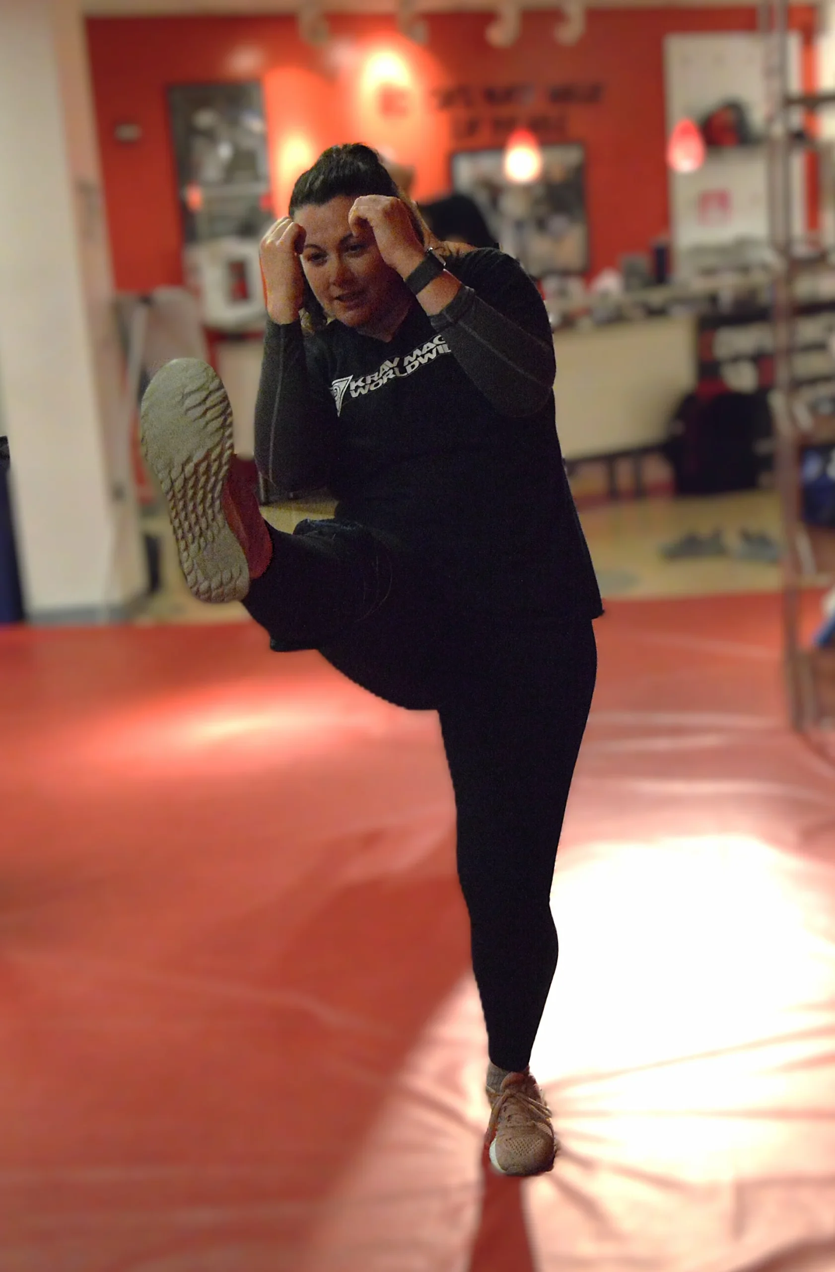 Woman practicing a front kick during private self-defense, Krav Maga, and fitness training in Bethesda, Maryland.