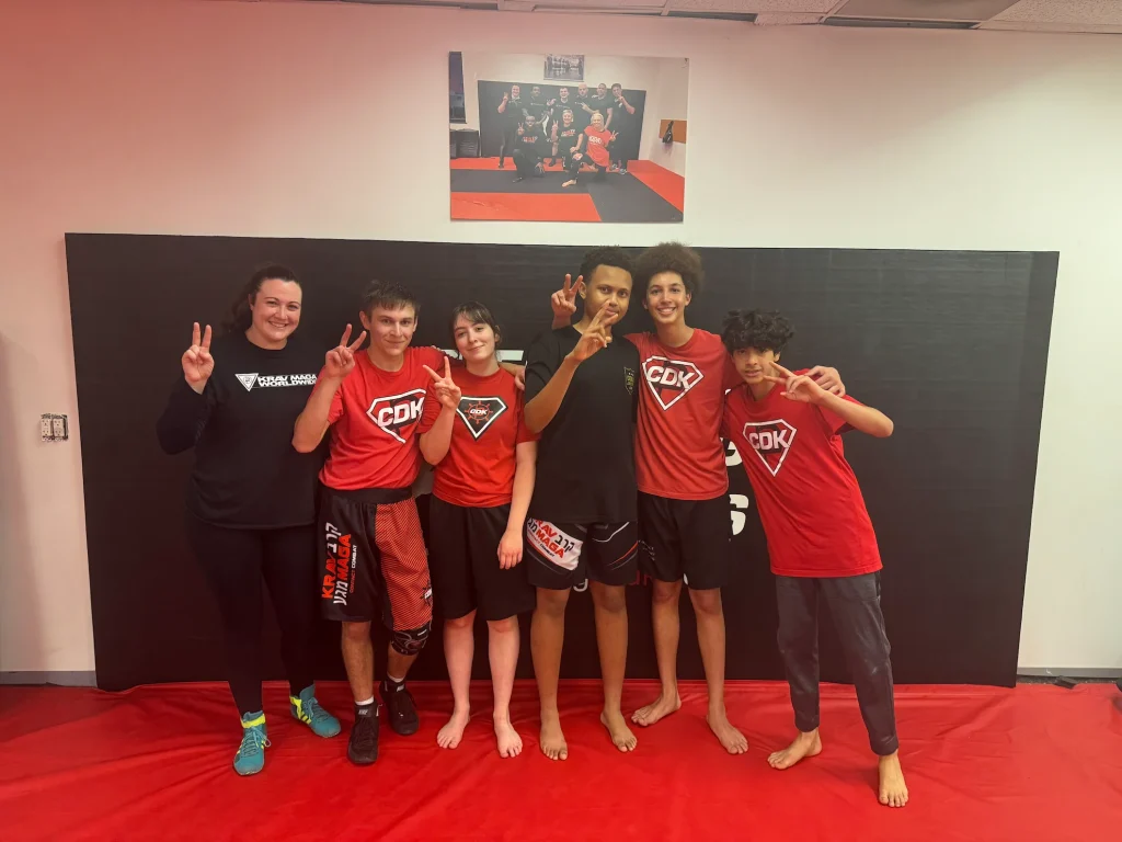 Teen students and their instructor posing together after a Krav Maga class in Bethesda, Maryland.